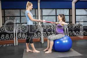 Trainer and pregnant woman using a resistance band