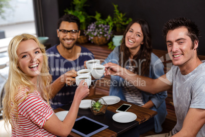 Smiling friends enjoying coffee together