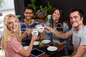 Smiling friends enjoying coffee together