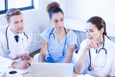 Medical team looking into laptop and having a discussion