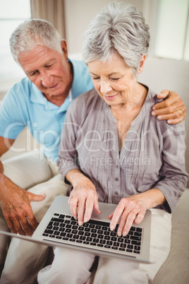 Senior woman using laptop in living room