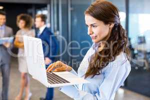 Confident businesswoman using laptop in office