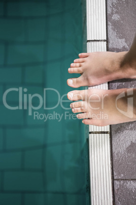 Feet of woman standing on the edge of the pool