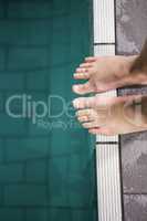 Feet of woman standing on the edge of the pool