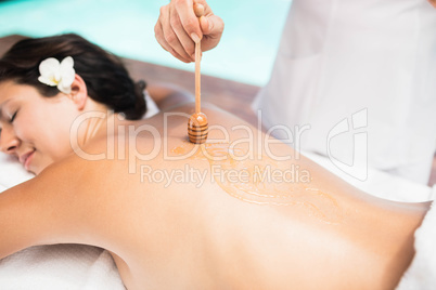 Woman receiving a honey massage from masseur