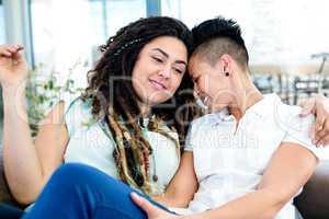 Happy lesbian couple relaxing on sofa