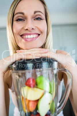 Pretty blonde woman preparing a smoothie