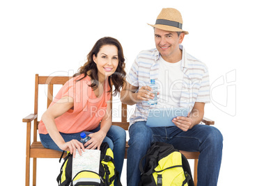 Couple on bench using tablet