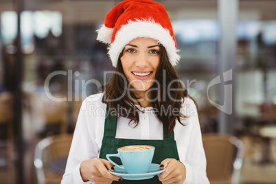 Woman with santa hat holding coffee