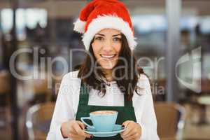 Woman with santa hat holding coffee