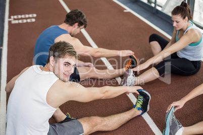 Four athletic women and men stretching