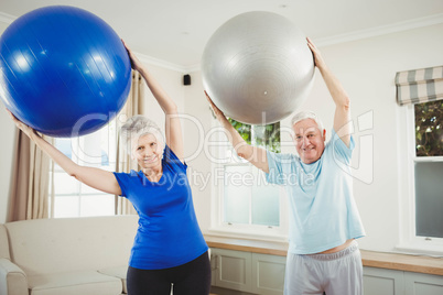 Senior couple exercising with exercise ball
