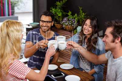 Smiling friends enjoying coffee together