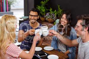 Smiling friends enjoying coffee together