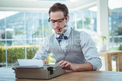 Handsome man using old fashioned typewriter