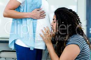 Woman kissing on pregnant partners stomach