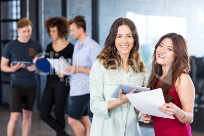 Portrait of women holding digital tablet and smiling