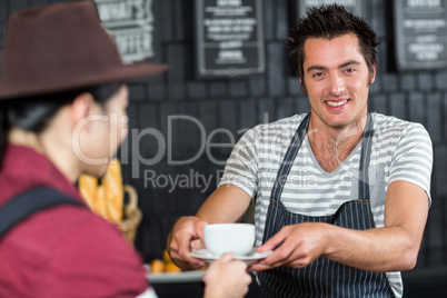 Waiter serving a coffee to a customer