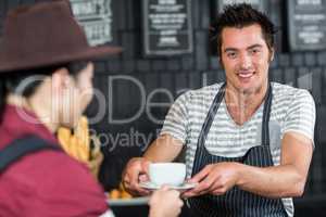 Waiter serving a coffee to a customer