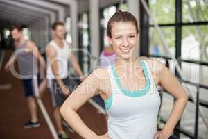 Smiling athletic woman posing with hands on hips