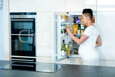 Pregnant woman looking for food in fridge