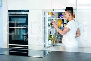 Pregnant woman looking for food in fridge