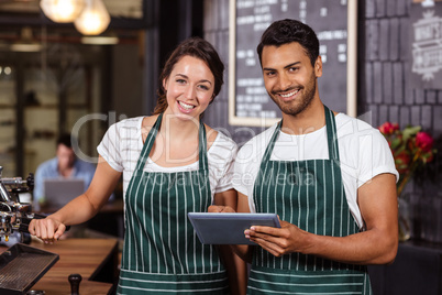 Smiling baristas using tablet