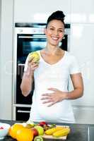 Pregnant woman holding a green apple