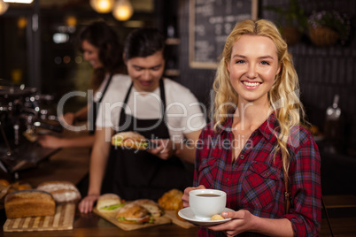 Smiling blonde customer in front of the counter