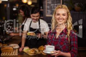 Smiling blonde customer in front of the counter