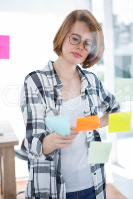 thoughtful hipster woman reading some post it notes