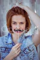 beautiful hipster woman holding a fake mustache