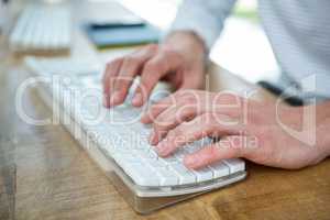 Masculine hands typing on keyboard