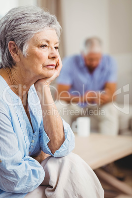 Worried senior woman sitting on sofa