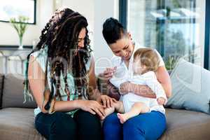 Lesbian couple playing with their baby