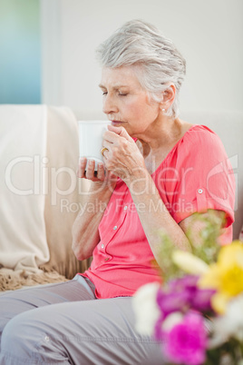 Senior woman smelling a cup of coffee