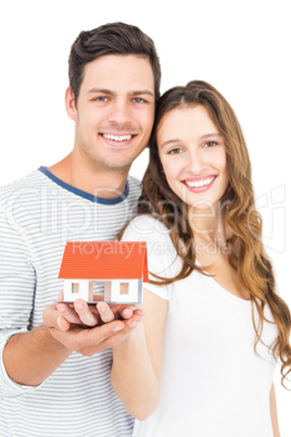 Happy couple holding miniature house