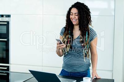 Woman standing near worktop with a mobile phone