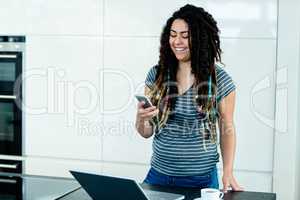 Woman standing near worktop with a mobile phone