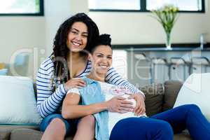 Pregnant lesbian couple with a pair of pink baby shoes