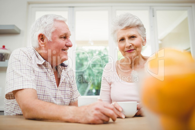 Senior couple talking to each other while having coffee