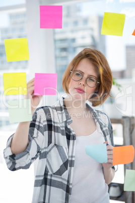 thoughtful hipster woman brainstorming over notes