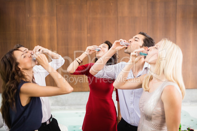 Young and handsome group of friends drinking shots