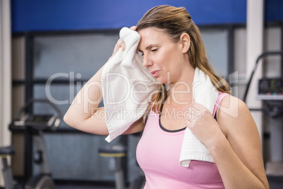 Tired pregnant woman wiping sweat with towel