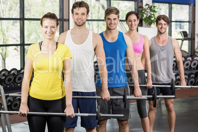 Fitness class lifting barbell