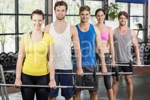 Fitness class lifting barbell