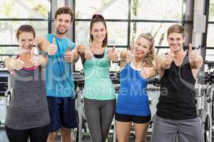 Athletic men and women posing with thumbs up