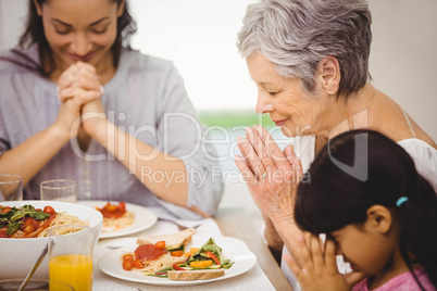 Family praying together before meal