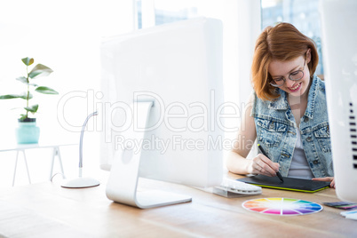 smiling hipster businesswoman drawing on a digital tablet
