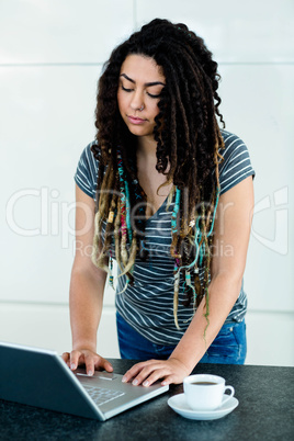 Woman using laptop in kitchen